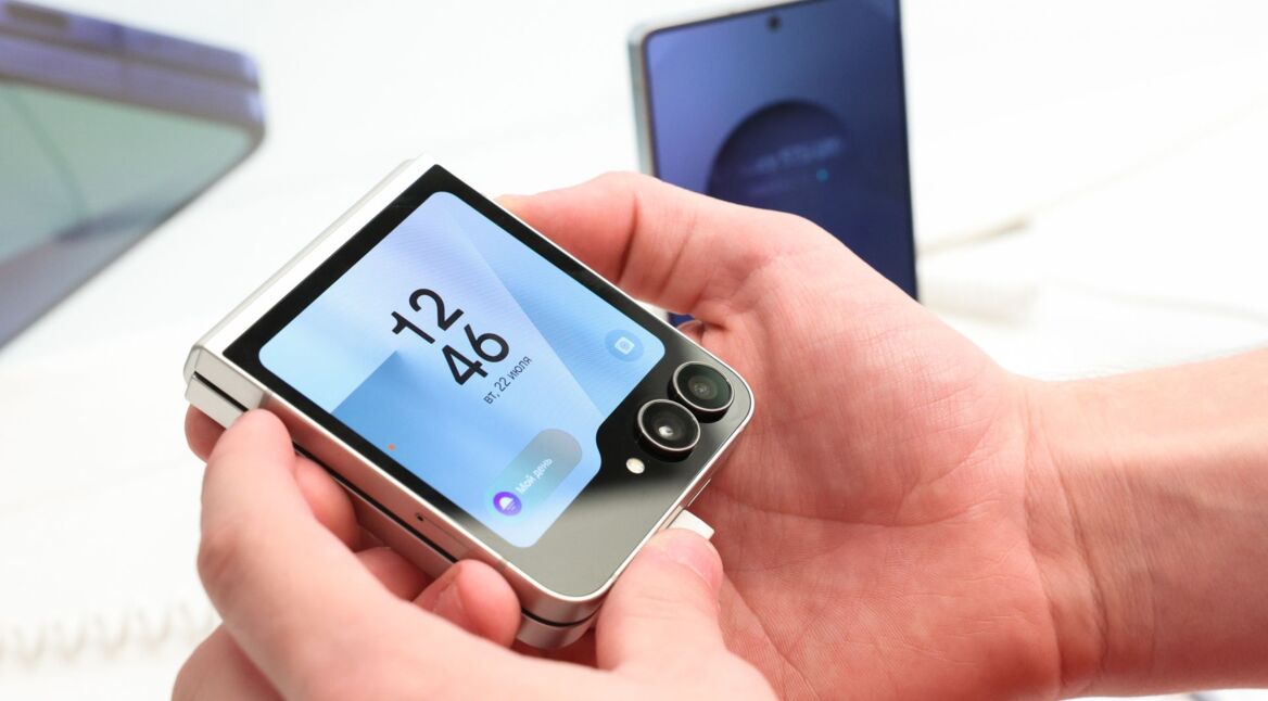 Eine Person hält das zugeklappte Galaxy Z Flip7 hoch.