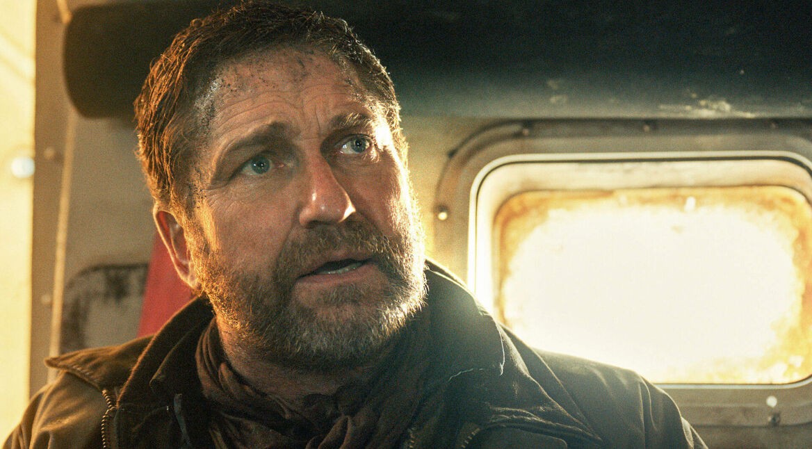 Gerard Butler in Greenland 2: Ein Mann blickt verzweifelt in einer Fahrzeugkabine bei grellem Licht.