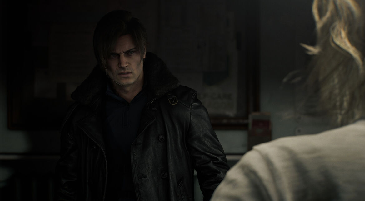 Leon S. Kennedy steht als einer der Resident Evil Requiem Charaktere in einem düsteren Raum. Er trägt eine schwarze Lederjacke mit Fellkragen und blickt ernst und konzentriert nach vorn. Im Vordergrund ist unscharf die Rückansicht einer weiteren Figur zu sehen, was auf eine Konfrontation oder wichtige Unterhaltung hindeutet.