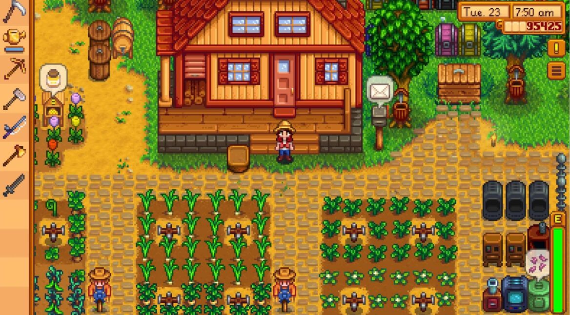 Auf dem Bild aus dem Videospiel Stardew Valley ist der Spieler-Charakter mit Strohhut, rotem Hemd und blauer Latzhose vor einem gemütlichen Farmhaus mit rotem Dach zu sehen. Gepflegte Felder mit Mais und grünen Pflanzen umgeben das Haus, während Maschinen und Kisten rechts platziert sind.
