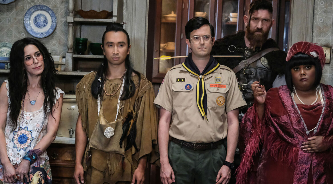 Produktionsbild aus „Ghosts“: Sam Arondekar steht mit mehreren Geistern der Woodstone Mansion in einem Raum, darunter Sasappis, Pete, Wikinger Thorfinn und Jazzsängerin Alberta.