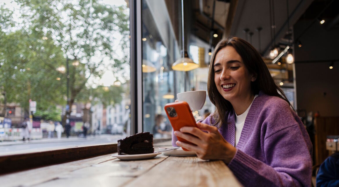 Eine Frau mit iPhone im Café
