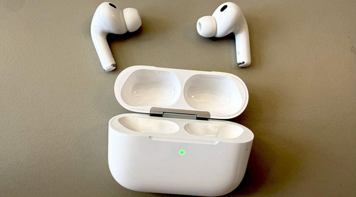 Die AirPods Pro 3 liegen neben ihrem Ladecase auf einer neutralen Oberfläche.