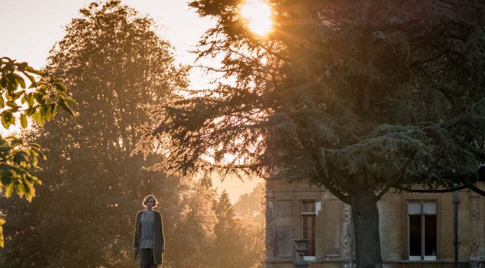 Frau geht in der Sonne auf Downton Abbey spazieren. Foto: Universal