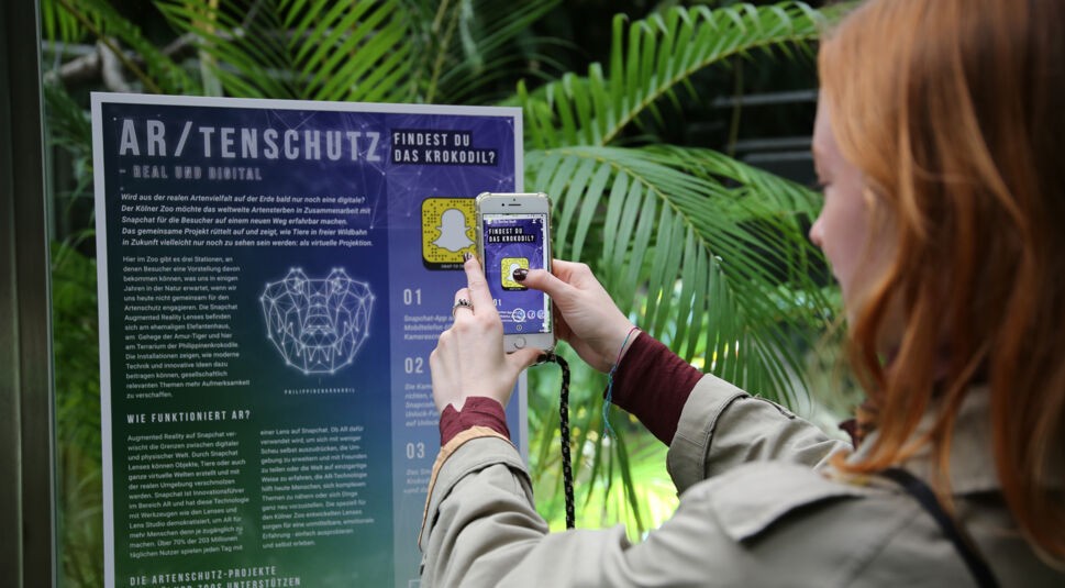 Handy scannt Snapchat-Schild zum ARtenschutz im Kölner Zoo