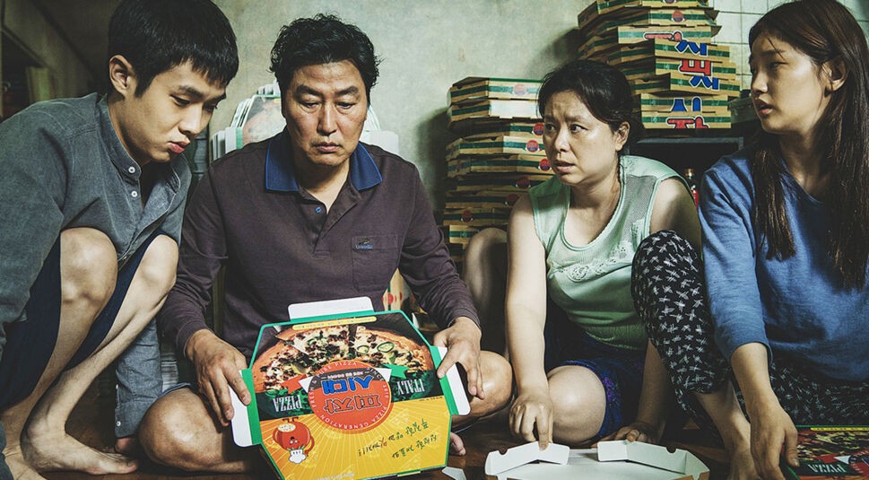 Die arbeitslose Familie Kim sitzt in "Parasite" auf dem Boden ihrer Wohnung und stapelt Pizzakartons. Foto: Koch Films / Capelight Films