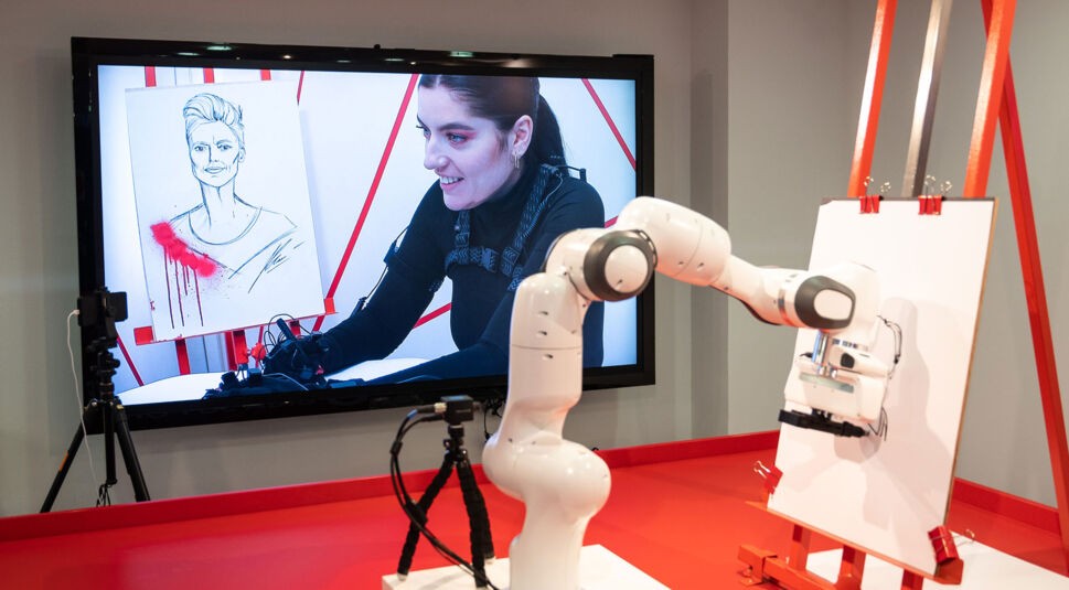 Ein Roboter zeichnet ein Portrait, indem er durch das 5G-Netz von Vodafone mit der Künstlerin Shev Lunatic verbunden ist.