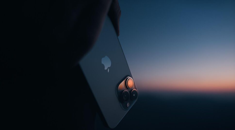 Das neue iPhone 13 vor einem Sonnenuntergang