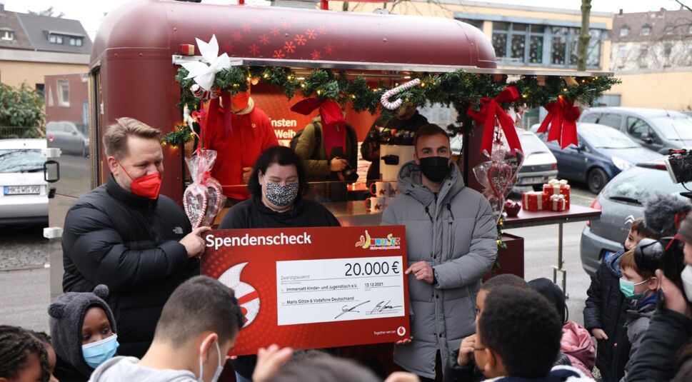 Mario Götze übergibt einen Spendencheck