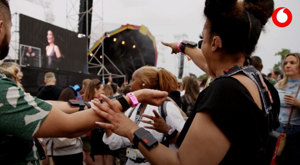 Frau mit 5G Haptikanzug vor Bühne