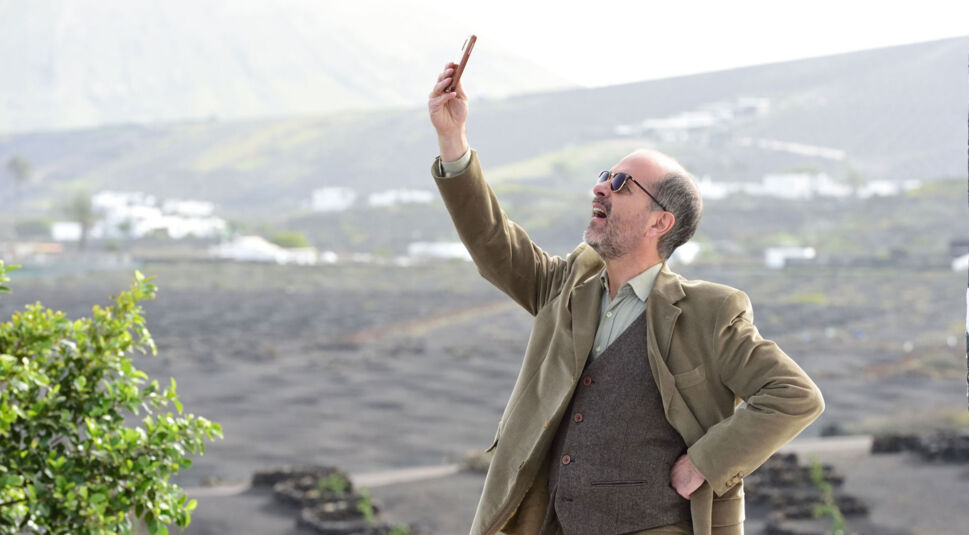 Mann hält Handy in die Höhe