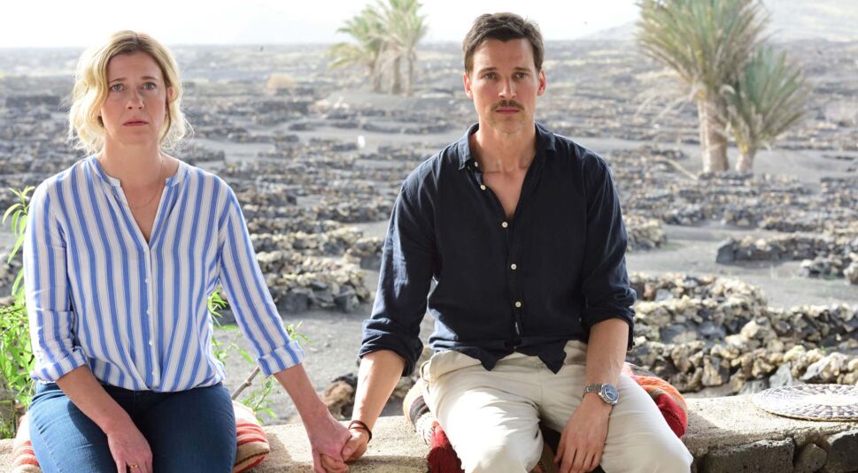 Pärchen sitzt verdutzt nebeneinander