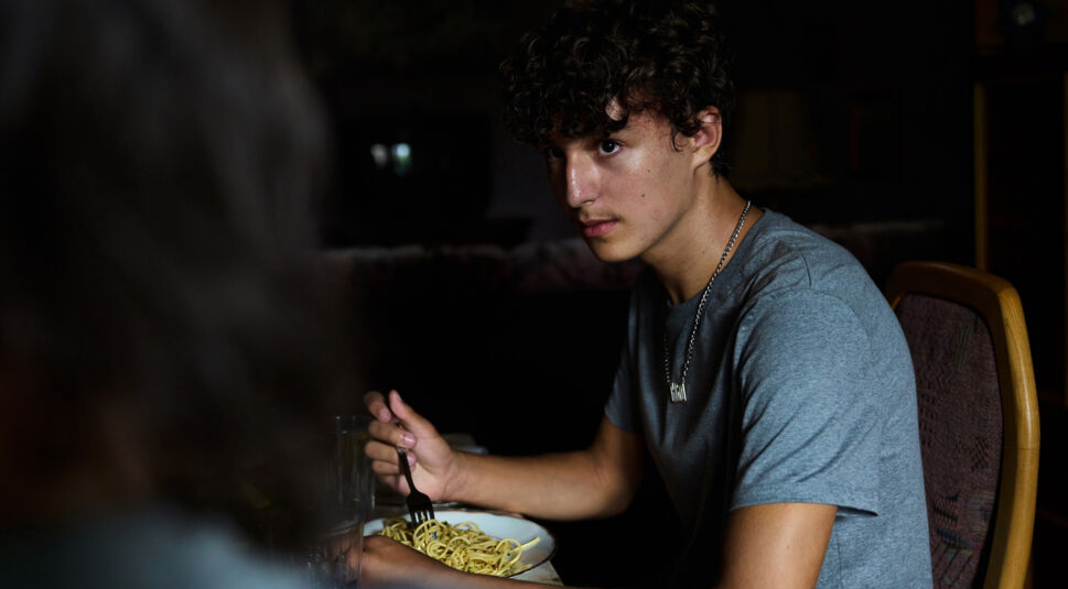 Gino (Rafael Klein-Heßling) im Gespräch mit seiner Mutter beim Abendessen im Film Sonne und Beton