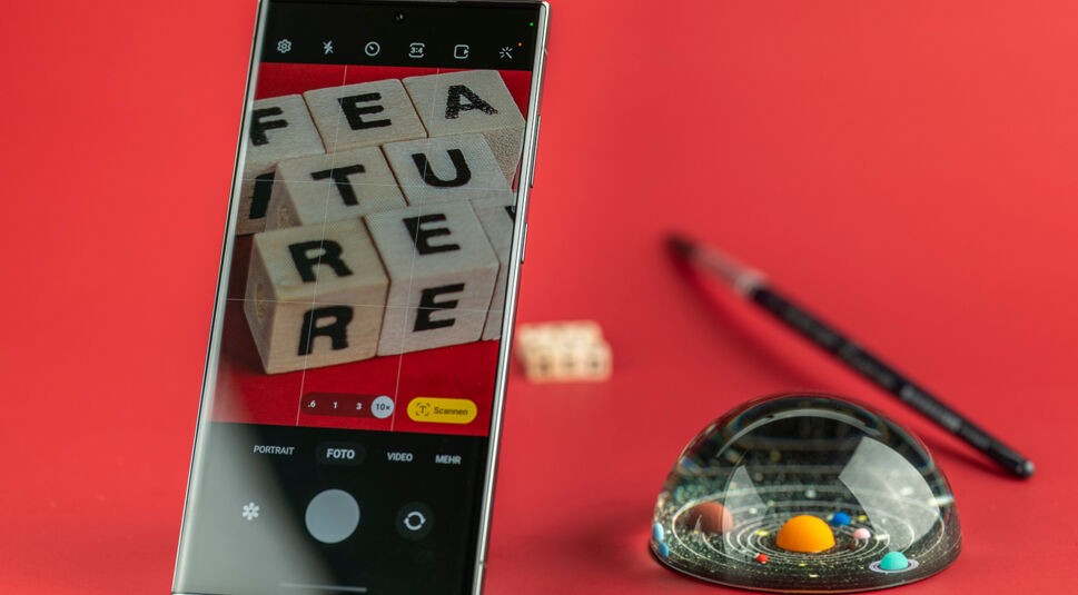 Display eines Smartphones zeigt Buchstabenwürfel