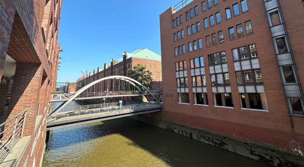Eine Brücke führt über einen Elbfleet zwischen roten Backsteinhäusern