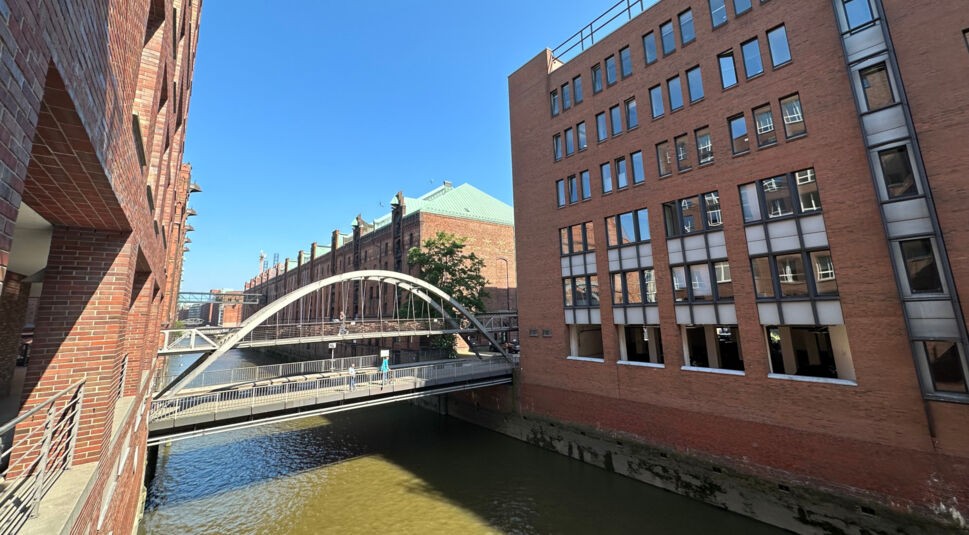 Eine Brücke führt über einen Elbfleet zwischen roten Backsteinhäusern