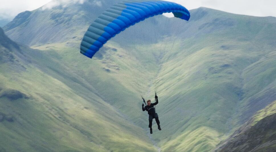 Tom Cruise fällt mit einem Fallschirm auf die Erde hinab.
