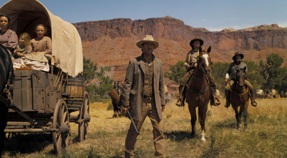 Like Wikson als Van Weyden mit einer Schrotflinte in der Hand vor einer Western-Kulisse.