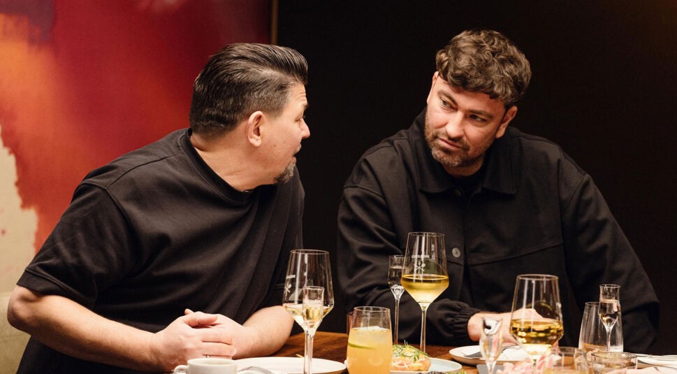 In dieser Szene aus Kitchen Impossible Staffel 10 unterhalten sich Tim Mälzer und Marteria intensiv bei einem Dinner.