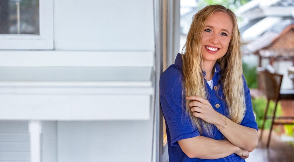 Auf dem Bild in dem Artikel zu Princess Charming 2025 lehnt eine Person mit langem blondem Haar an einer weißen Wand.