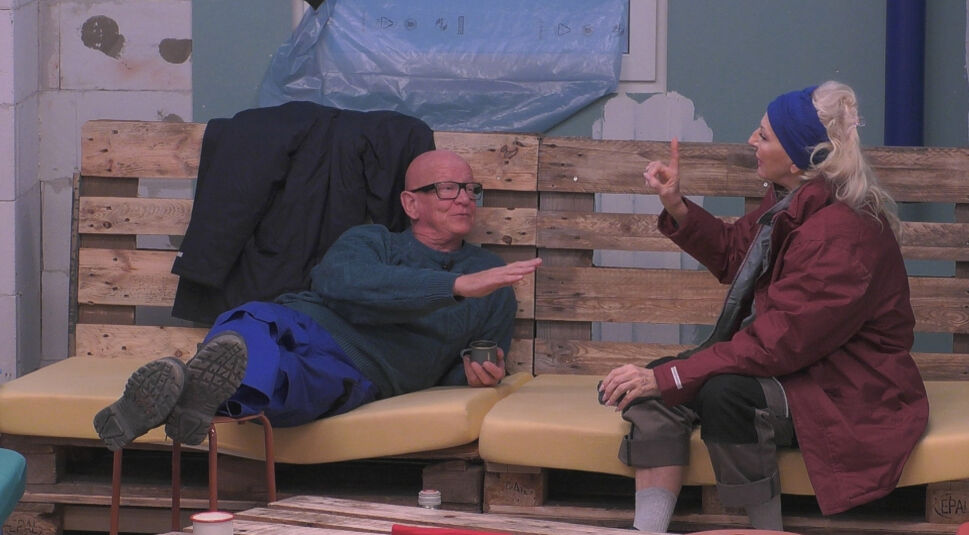 In dieser Szene aus „Promi Big Brother“ 2025 sitzen zwei Bewohner:innen auf einer Couch aus Paletten.