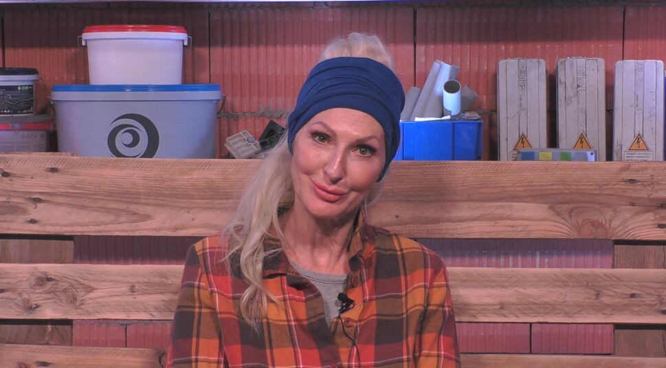 In dieser Szene aus „Promi Big Brother“ 2025 sitzt eine Bewohnerin im „Rohbau“ auf einer Bank aus Holzpaletten.