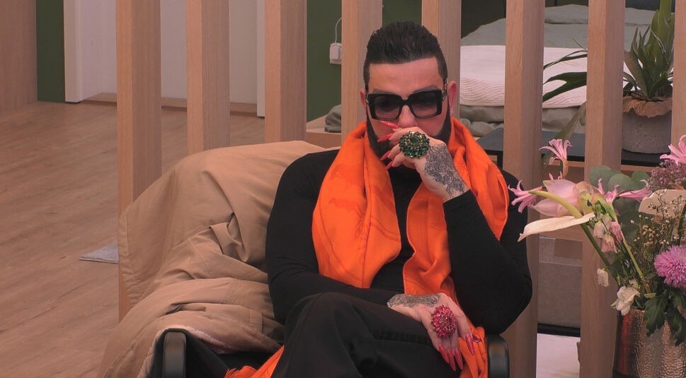 In dieser Szene aus „Promi Big Brother“ 2025 sitzt ein Bewohner in der „Musterwohnung“ auf einem Sessel.