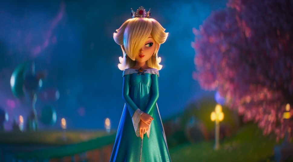 In dieser Szene aus Der Super Mario Galaxy Film ist Rosalina zu sehen, gesprochen von Brie Larson. Sie steht in einem sanft beleuchteten, farbenfrohen Garten, trägt ein glitzerndes türkisfarbenes Kleid und eine kleine Krone. Ihre ruhige, anmutige Haltung und der märchenhafte Hintergrund erzeugen eine träumerische, warme Stimmung.