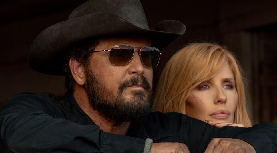 Auf dem Bild zur Dutton Ranch sind Kelly Reilly als Beth Dutton und Cole Hauser als Rip Wheeler in einer intensiven Nahaufnahme zu sehen. Rip trägt Cowboyhut und Sonnenbrille, wirkt ruhig und entschlossen, während Beth mit sichtbaren Kratzern im Gesicht nachdenklich wirkt. Die Szene vermittelt eine ernste, emotionale und spannungsgeladene Atmosphäre im Western-Stil.