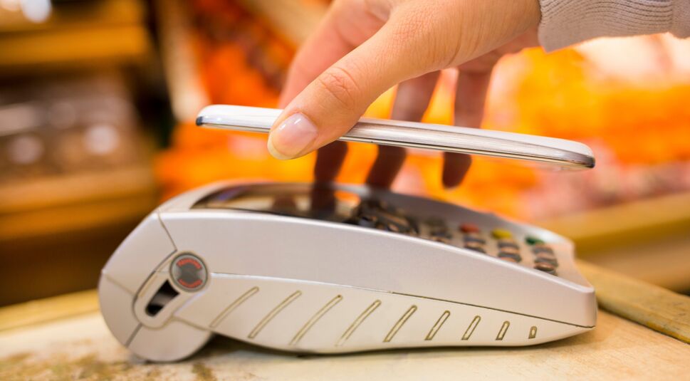 Woman paying with nfc technology on mobile phone, shopping, supe