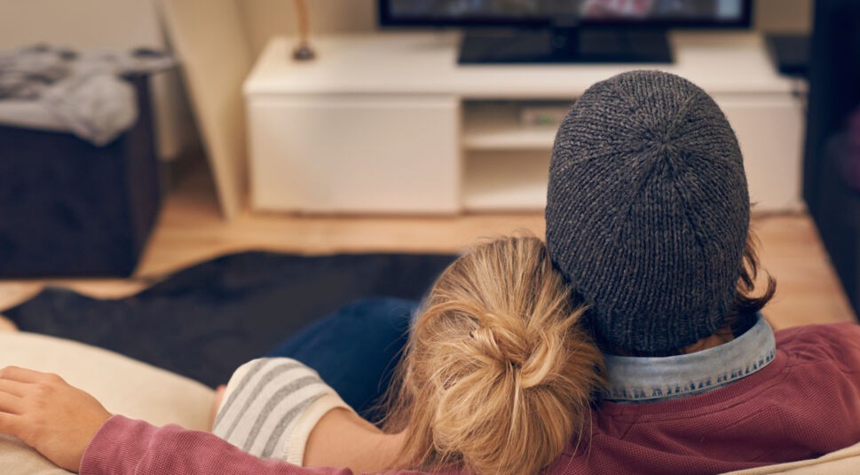 Rear view shot of a young couple watching TV together