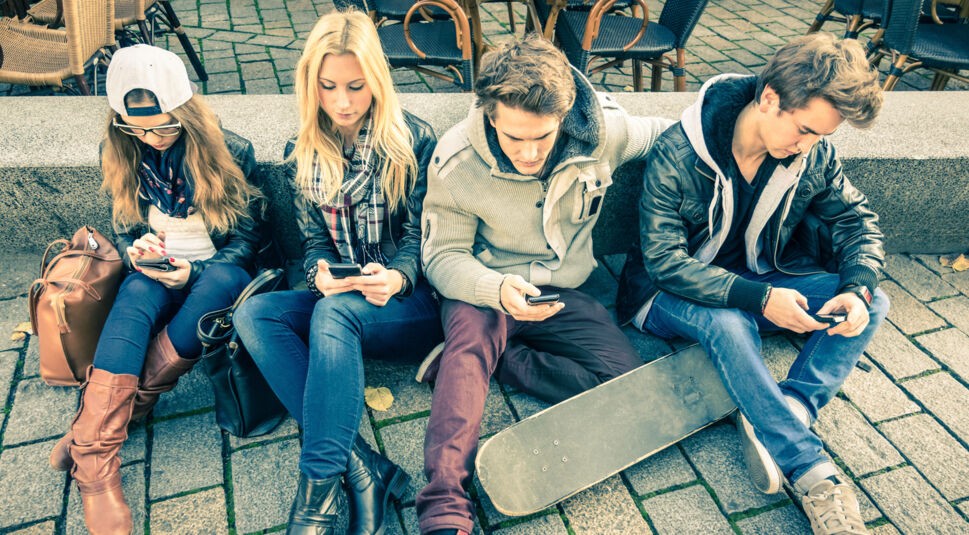 Group of young hipster friends playing with smartphone with mutual disinterest towards each other - Modern situation of technology interaction in alienated lifestyle - Internet wifi connection