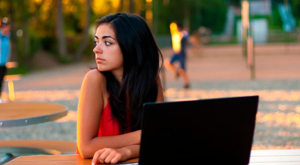 Serious girl with laptop outdoors