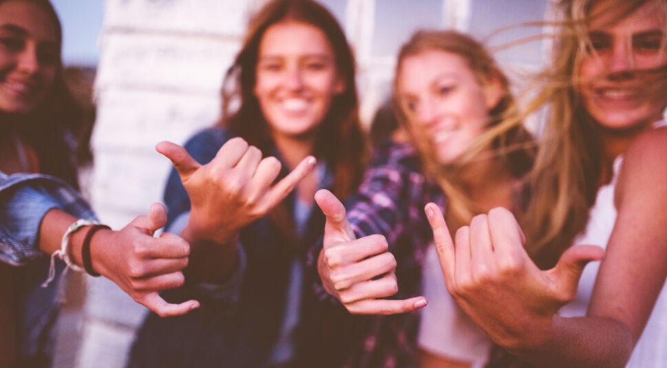 Teen friends posing making fun-loving hand gestures