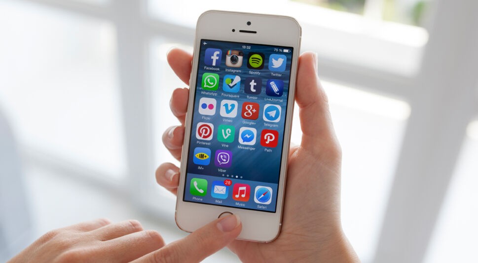woman hands holding iPhone with social program on the screen