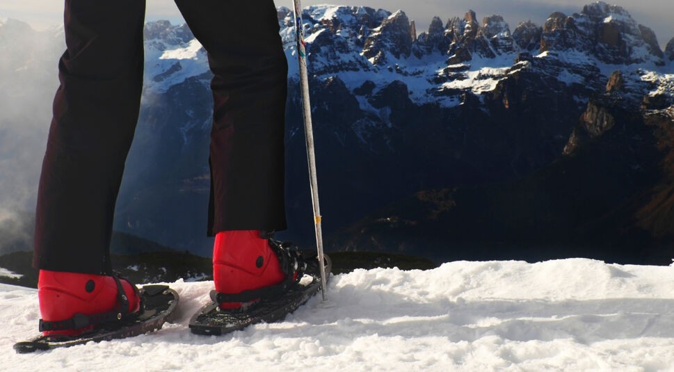 Skier in red winter jacket with  small fun skis stay in snow