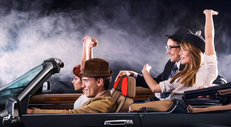 Group of young people in an old timer car.