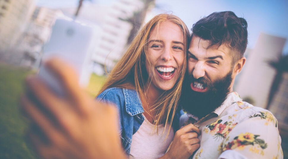Guy pulling funny face for a selfie with his girlfriend