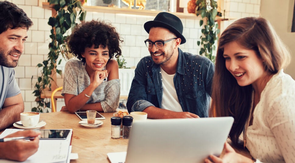 Friends hanging out at cafe with laptop