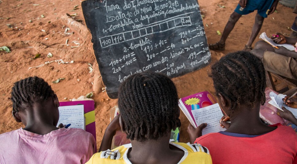 Bie, Angola - May 10, 2013. Three girls undertake a maths exam by a tree in a rural school. Access to education in low income countries of sub-saharan Africa is one of the challenges of the global community, as stated in the Sustainable Development Goals.