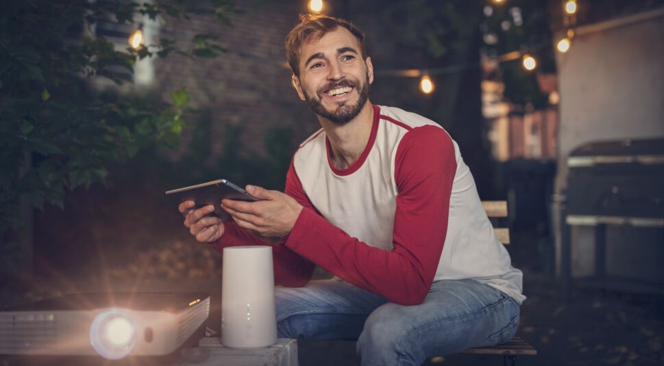 Ein Mann nutzt den GigaCube für WLAN im Garten um etwas zu Streamen