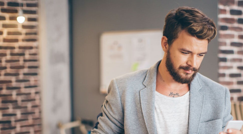 Mann macht ein Update auf dem Smartphone rückgängig.