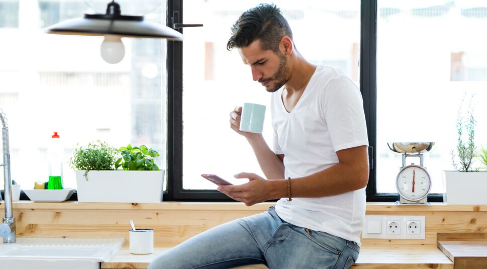 Mann schaut sich Smartphone an.