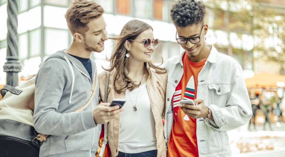 Drei Freunde mit Smartphones.