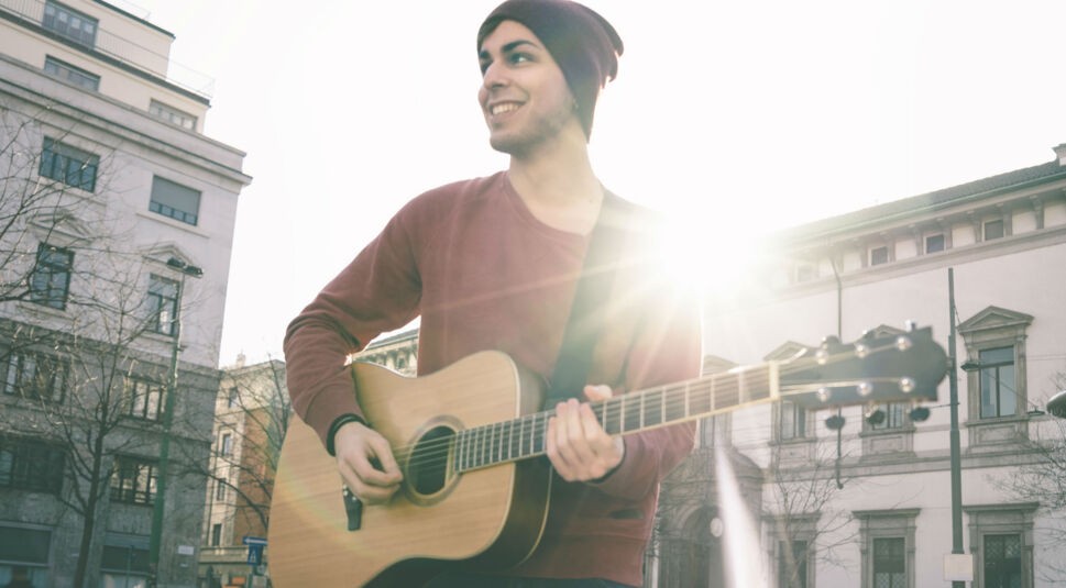 Junger Mann spielt Gitarre.