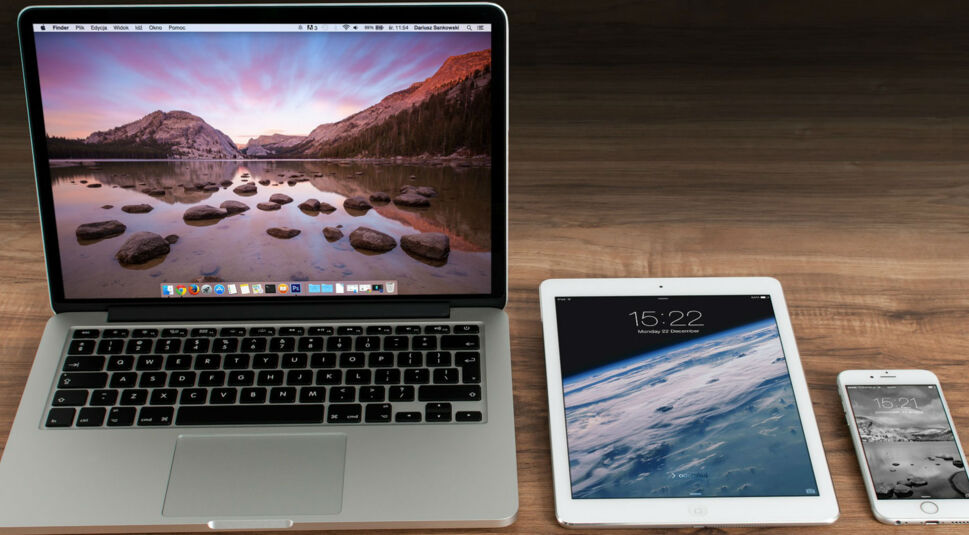 Macbook, iPad und iPhone auf Holztisch.