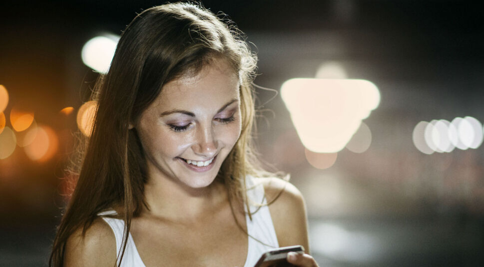 Mädchen benutzt Smartphone nachts.