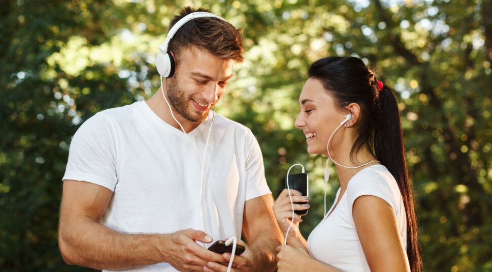 Mann und Frau beim Joggen mit verschiedenen Kopfhörersystemen