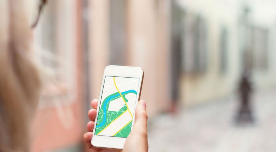 Junge Frau nutzt Apple Maps zur Navigation mit dem iPhone.