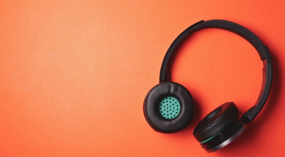 Kabellose Kopfhörer vor orangem Hintergrund